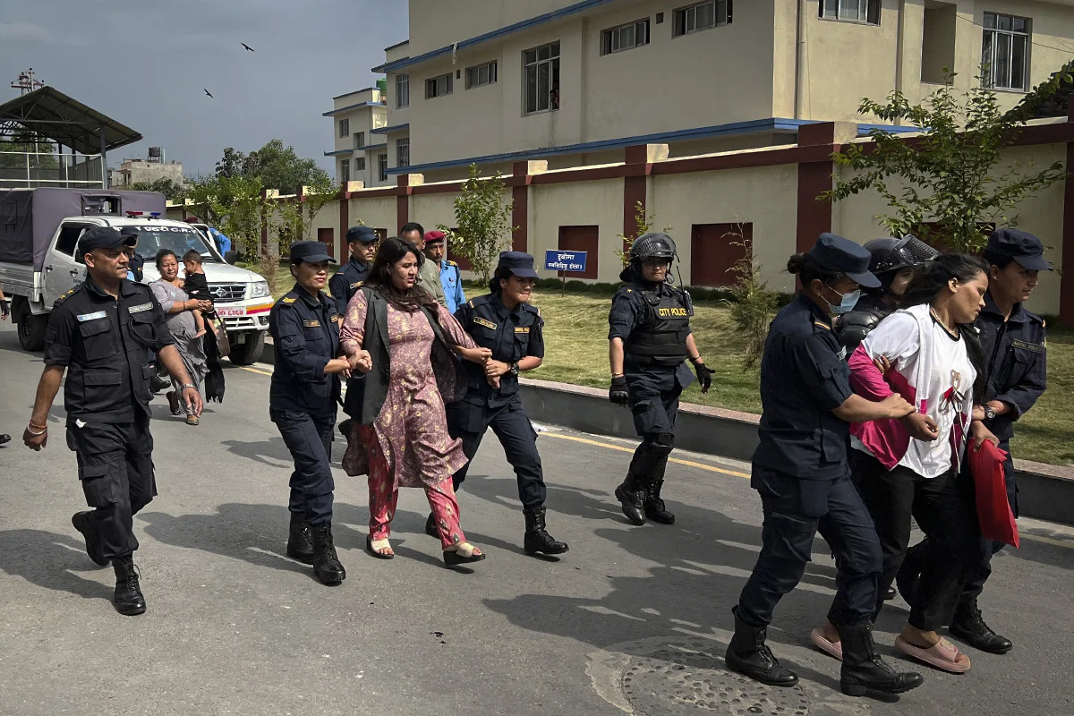 Полицейские выводят с территории МИДа Дипу Сингх Шахи (на переднем плане) и Криту Бхандари (на заднем). Фото: Ирина Кравцова / «Новая газета Европа»