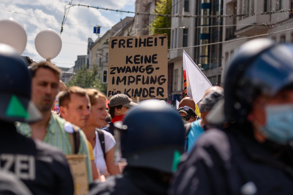 Участники митинга в Берлине держат плакат с призывом против обязательной вакцинации детей во время шествия против коронавирусных ограничений, 29 августа 2020 года. Фото: Jan Scheunert / ddp / Vida Press