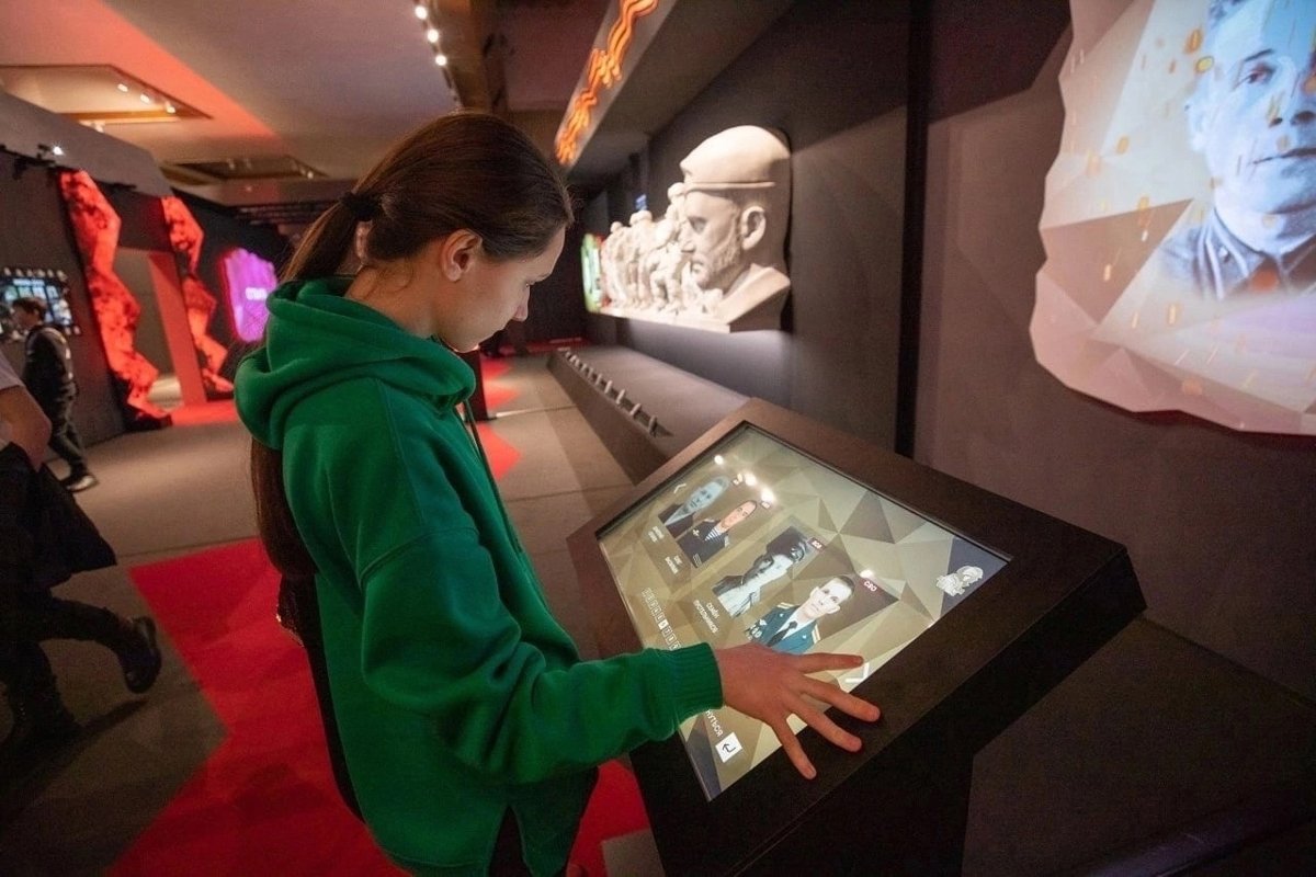 Экран с участниками войны в Украине в музее Победы на выставке «Zаветам Vерны», июль 2024 года. Фото: страница музея в VK