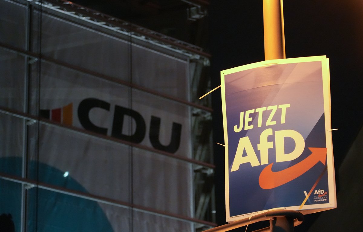 Плакат AfD на фоне логотипа партии  CDU  в Берлине, 30 января 2025 года. Фото: Manuel Genolet / dpa / picture-alliance / Scanpix / LETA